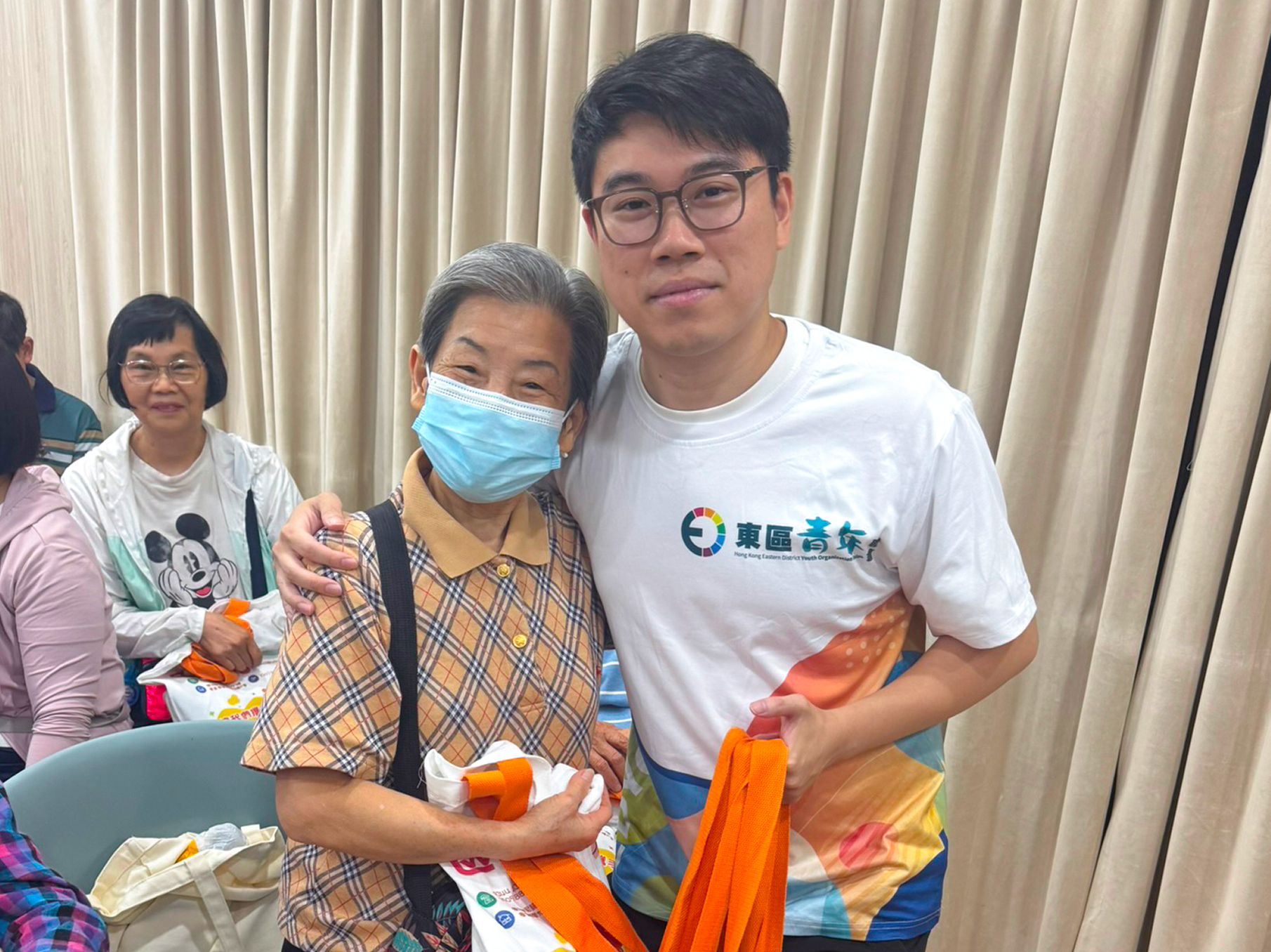 東區青年義工與長者合影，展示環保手挽袋